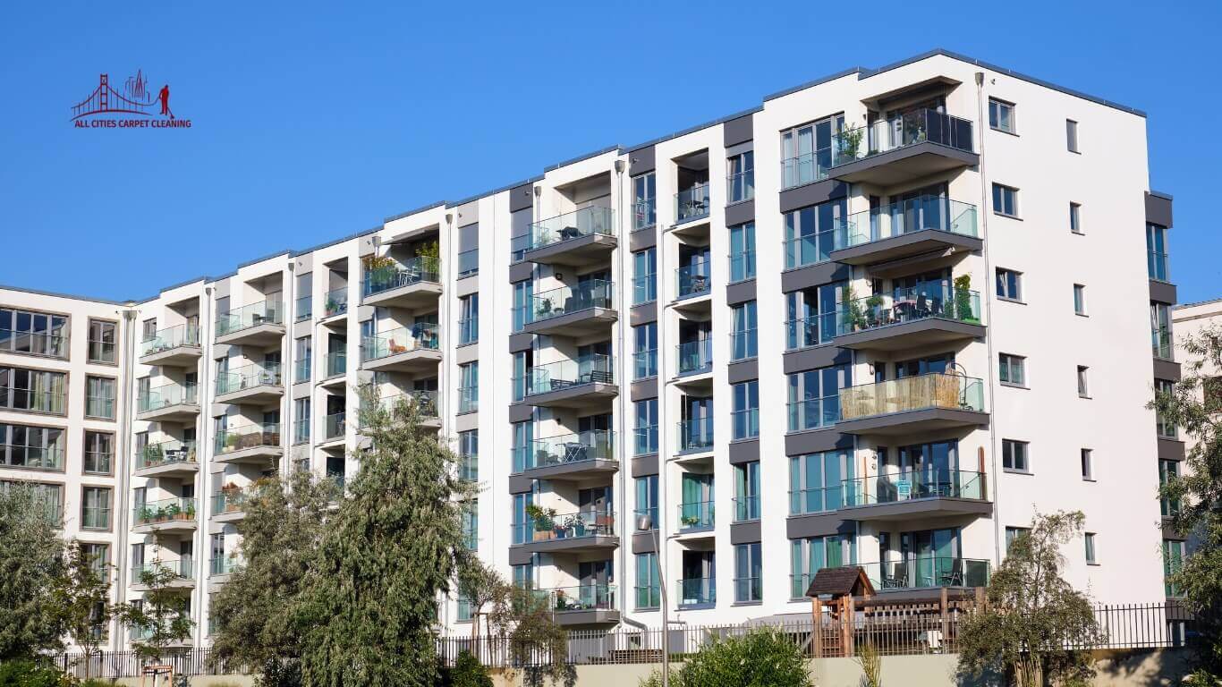 Seven-story apartment and condo building exterior with trees and blue sky, representing carpet cleaning services for apartments and property managers