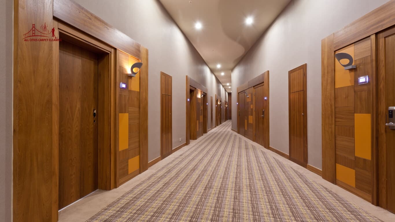 Luxury hotel hallway common area fully carpeted with light bulbs on ceiling representing professional hotel carpet cleaning and maintenance services