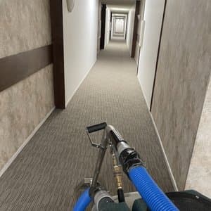 Hotel hallway fully carpeted with professional carpet cleaning equipment handle cleaning the hallway